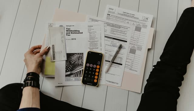 Consultant reviewing tax forms with a calculator and pen